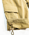 Close-up of beige pants with a drawstring on a white background