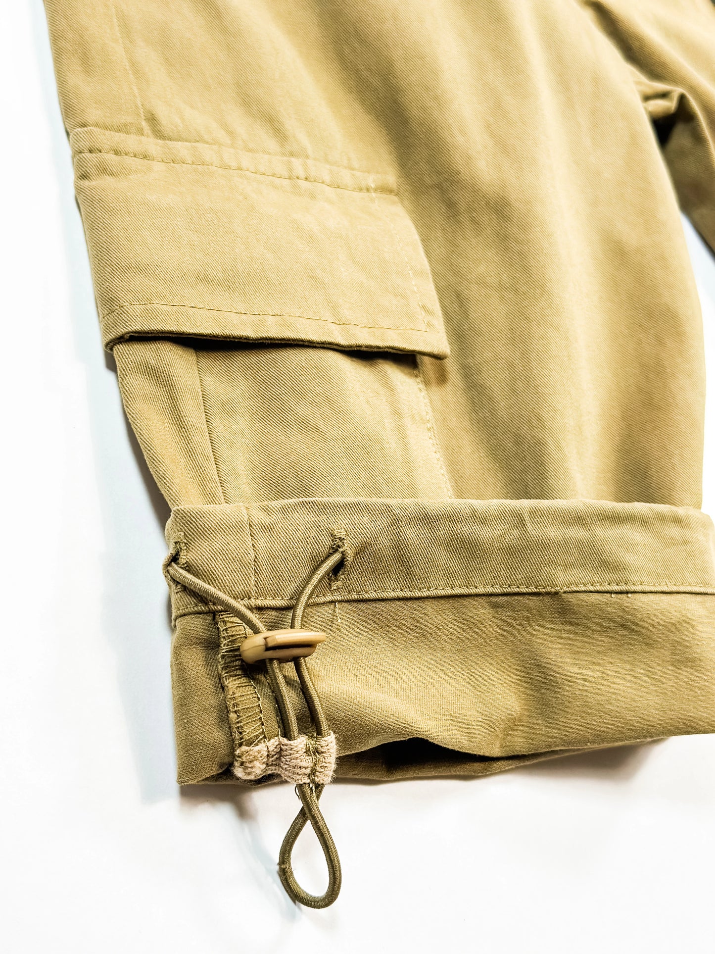 Close-up of beige pants with a drawstring on a white background