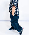Child wearing a black shirt with dinosaur pattern and dark pants on a white background