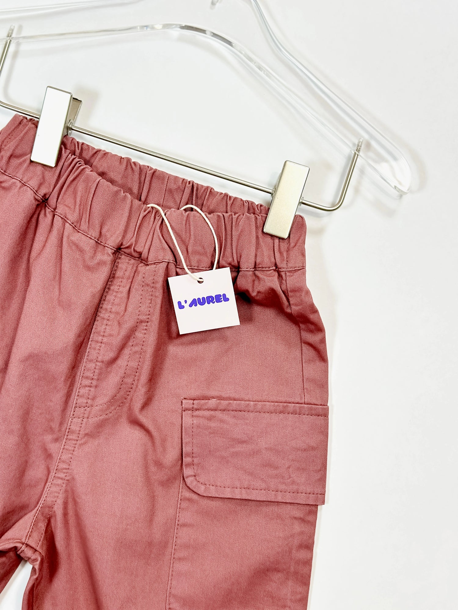 Pink pants on a hanger with a 'Laurel' tag.