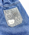 Blue denim jacket with embroidered dog faces on a pocket

