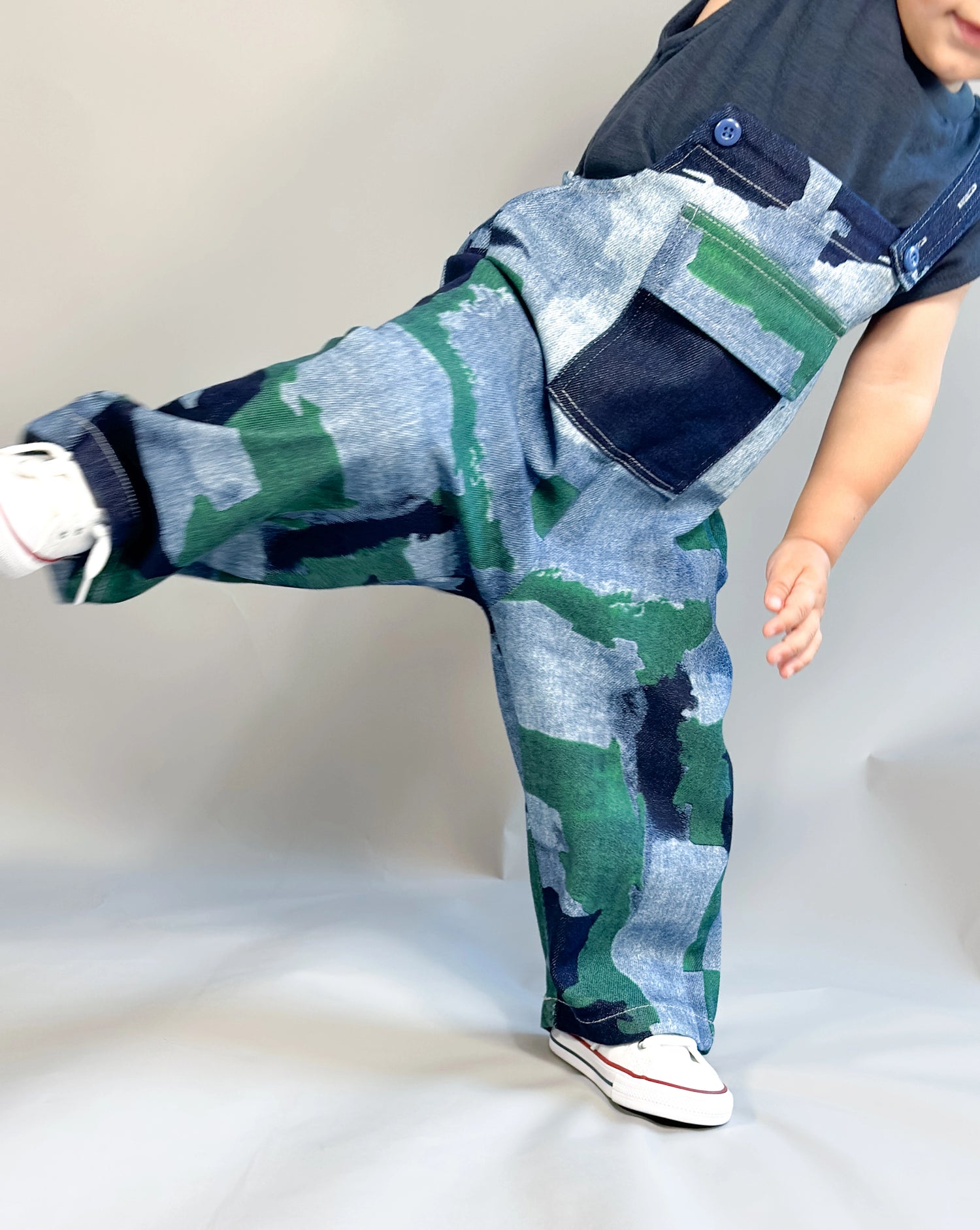 Toddler boys’ overalls in denim optic with blue and green camo-style wash – adjustable straps and front pocket, bold and playful design by Little Aurel