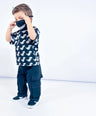 Child wearing a black Little Aurel t-shirt with white dinosaur print and black cargo pants on a white background