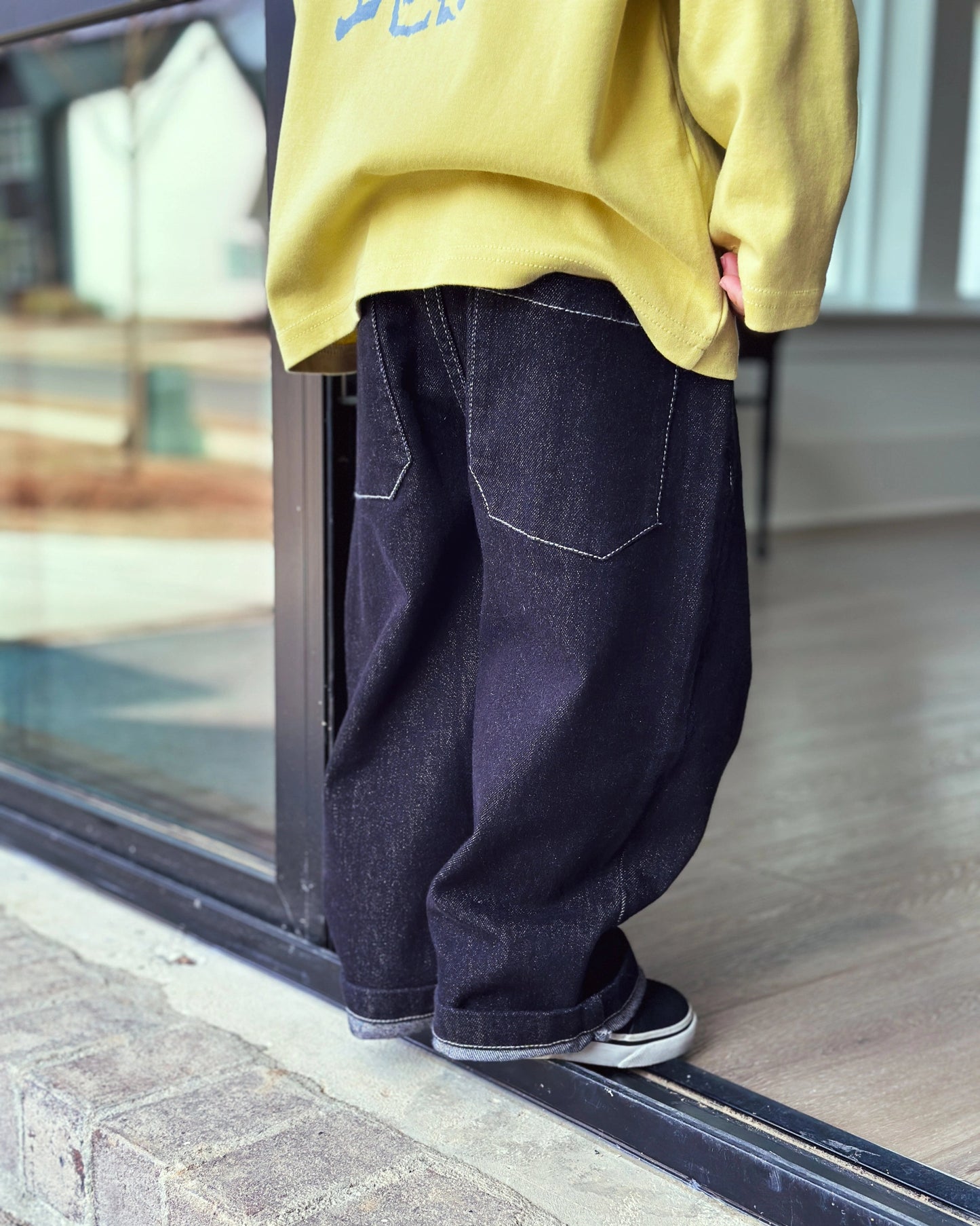 Child model wearing easy-fit denim pants with soft pistachio longsleeve from Little Aurel