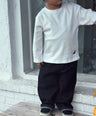 Child model wearing Loose-fit longsleeve shirt for kids in white with small dinosaur embroidery