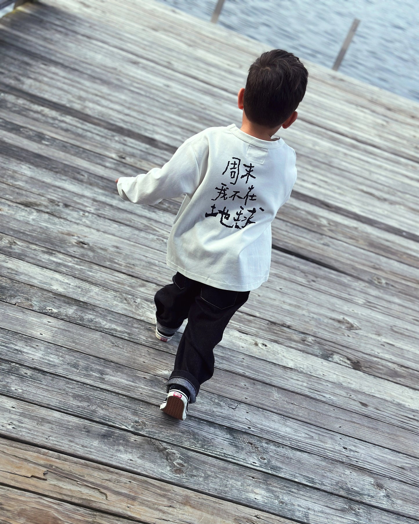 Child wearing oversized graphic longsleeve in white from Little Aurel