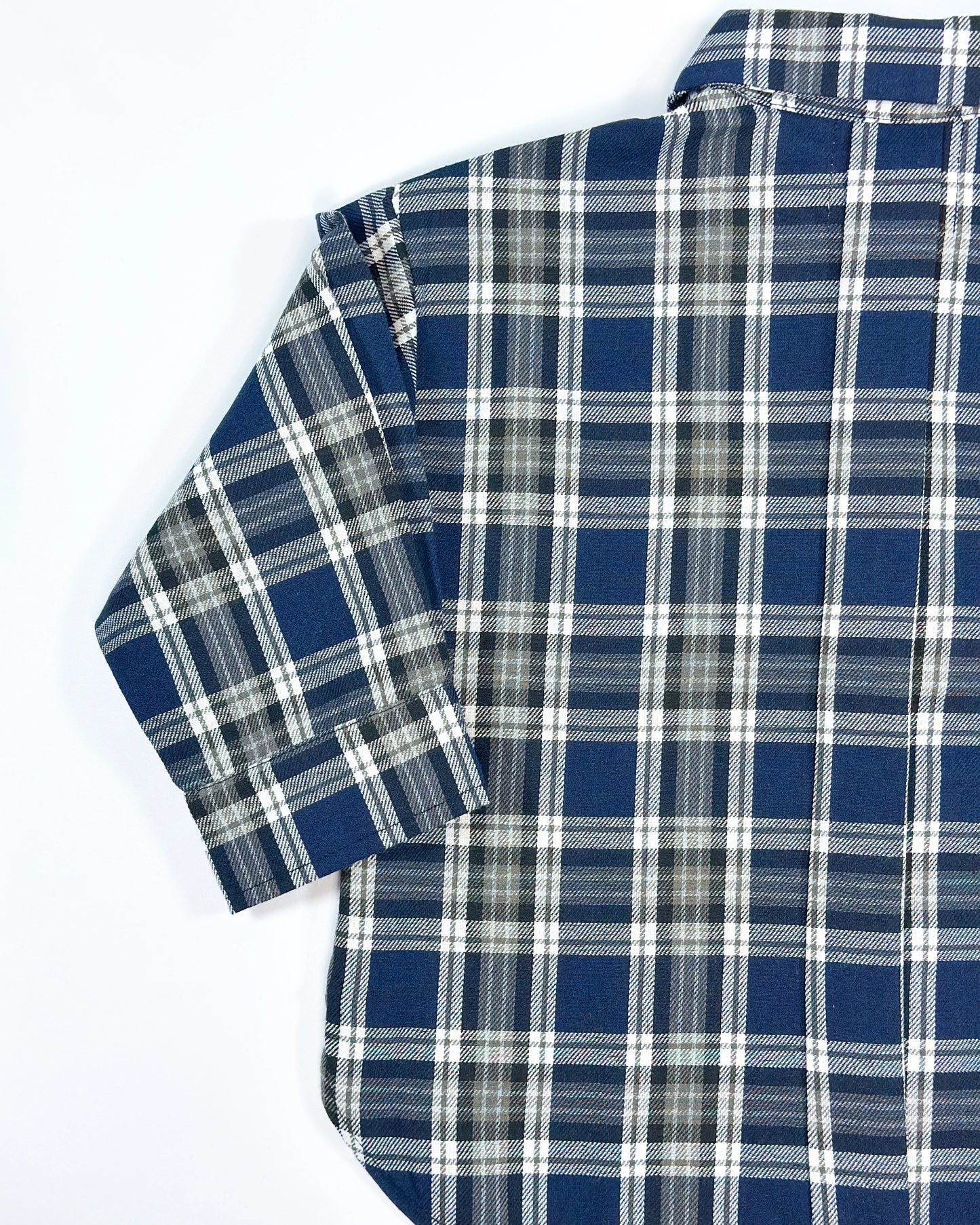 Oversized plaid blouse for toddler boys in navy and grey with front pocket and button-down design by Little Aurel.