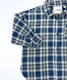 Oversized plaid blouse for toddler boys in navy and grey with front pocket and button-down design by Little Aurel.