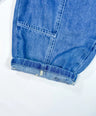 Close-up of a rolled-up blue denim sleeve on a white background