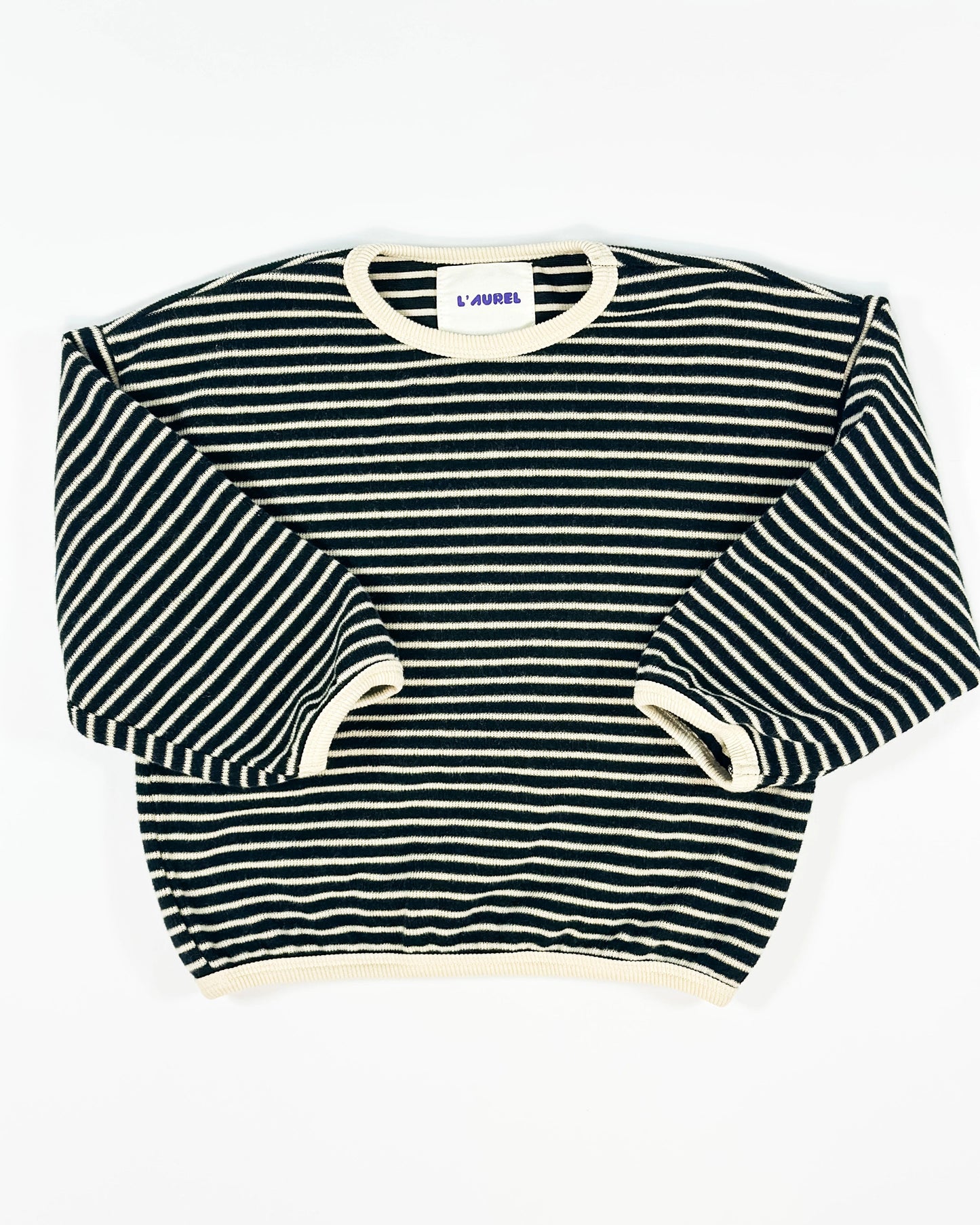 Black and white striped knit pullover for toddler boys with cream neckline and cuffs by Little Aurel