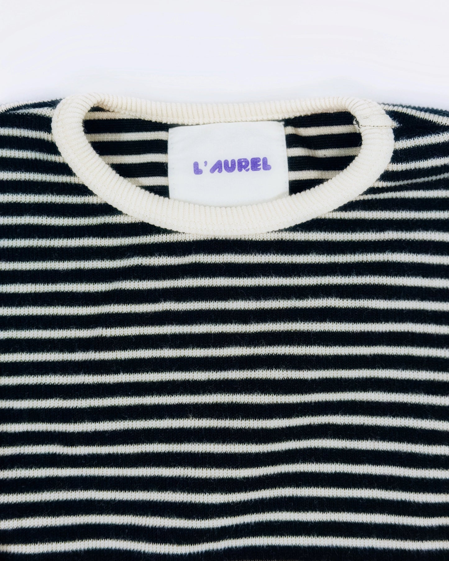 Black and white striped knit pullover for toddler boys with cream neckline and cuffs by Little Aurel