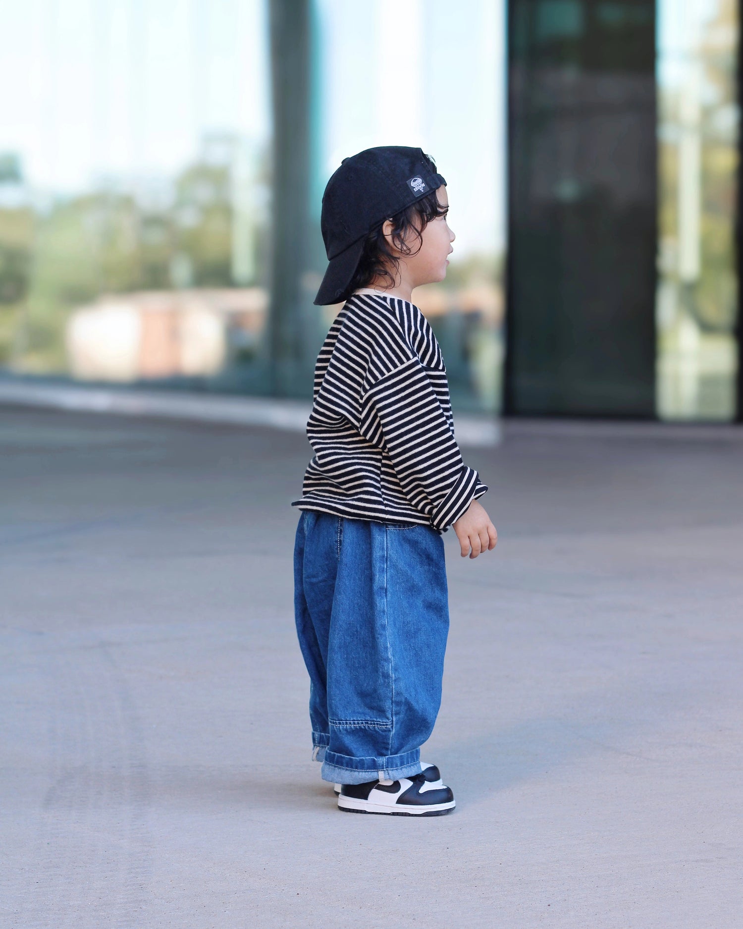 Black and white striped knit pullover for toddler boys with cream neckline and cuffs on our model by Little Aurel
