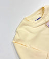 Light yellow sweatshirt with a brand tag on a light gray background by L'aurel