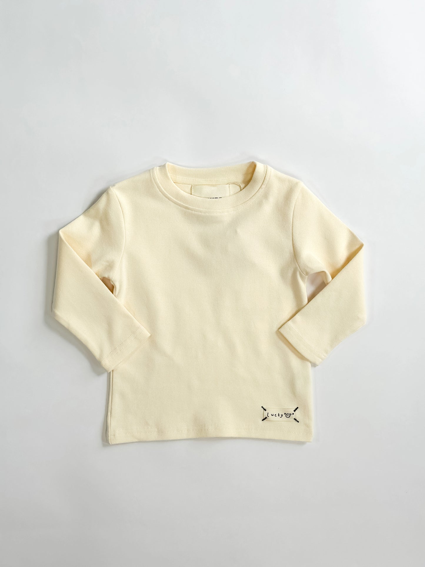 Creme long-sleeve shirt on a light gray background by L'aurel