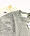 Gray and creme longsleeve shirt with a tag on a white background by L'aurel