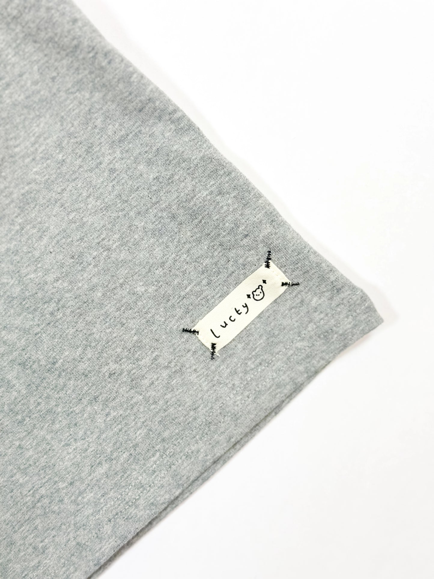 Gray fabric with a 'lucky' label on a white background by L'aurel