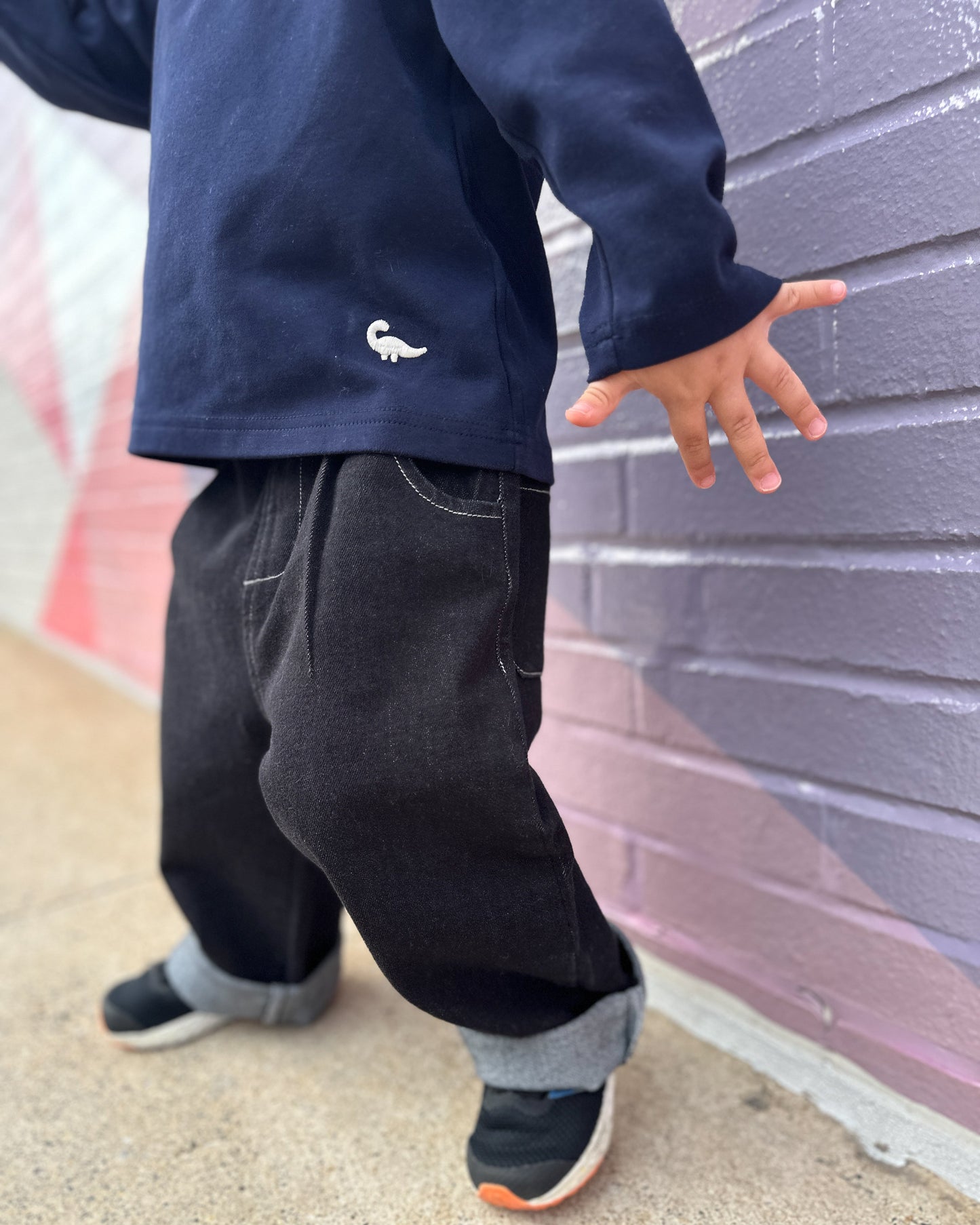 Child model wearing Loose-fit longsleeve shirt for kids in navy blue with small dinosaur embroidery