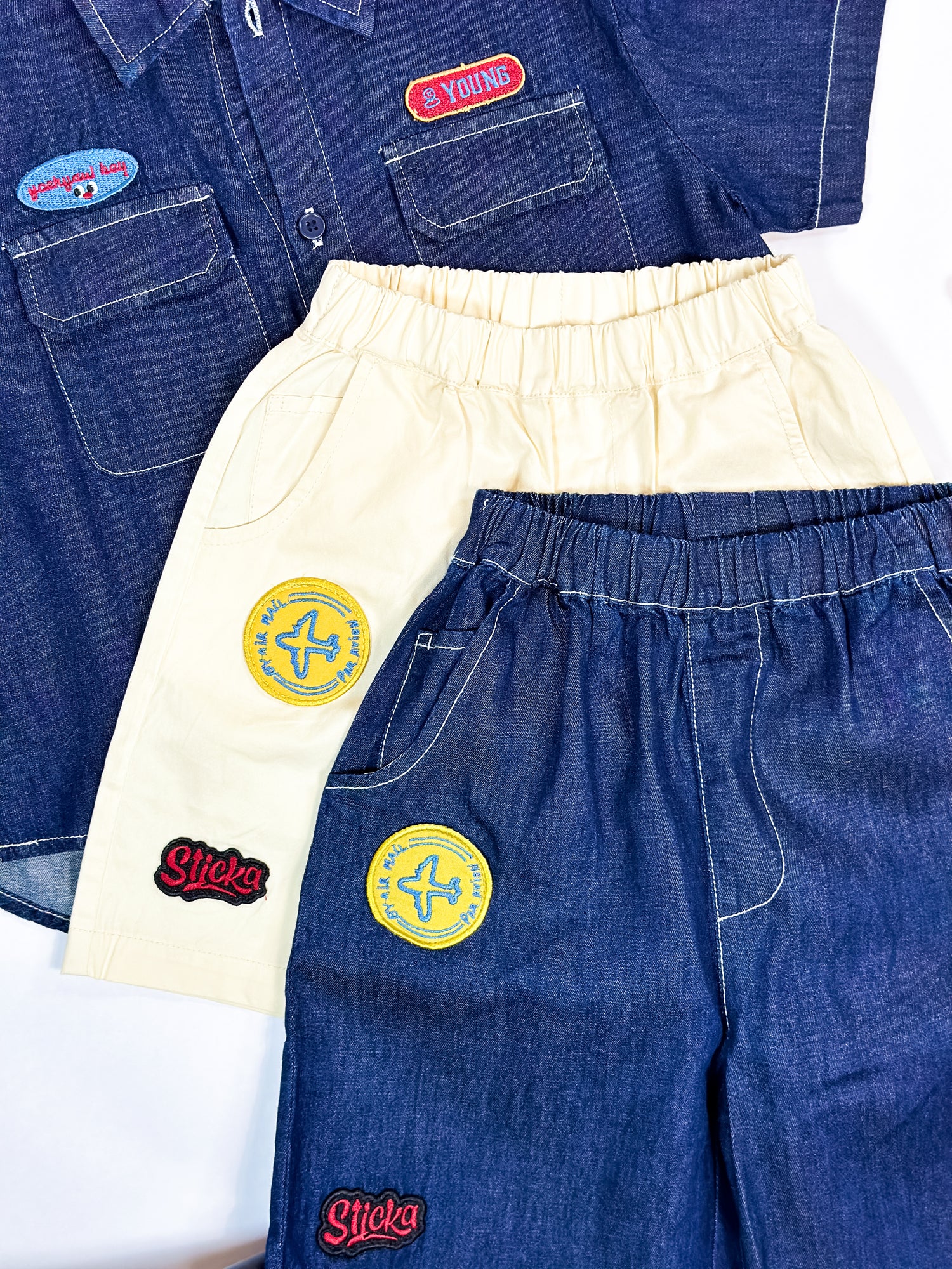 Two pairs of pants with patches on a white background by Laurel