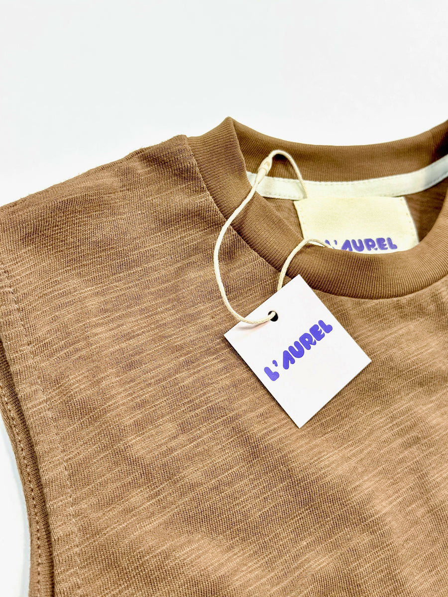 Brown garment with a 'L'Aurel' tag on a white background